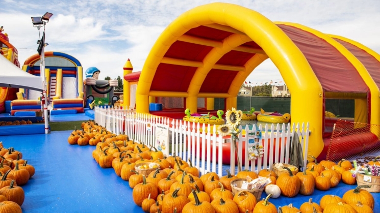 giant inflatable surrounded by pumpkins at a pumpking patch