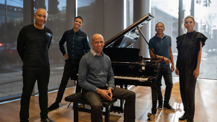group standing in front of piano
