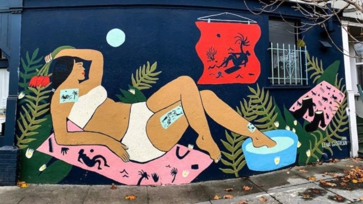 "way's to remember" mural of a woman laying with her feet in a pedicure tub holding flowers