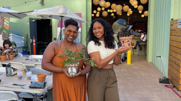 Friends Smiling with plants at Hella Plants Market. Photo courtesy of company website.