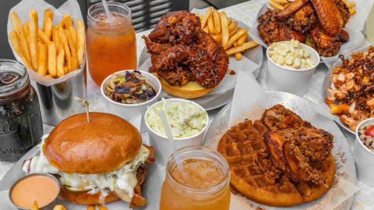 spread of different fried chicken dishes and drinks from Kowbird