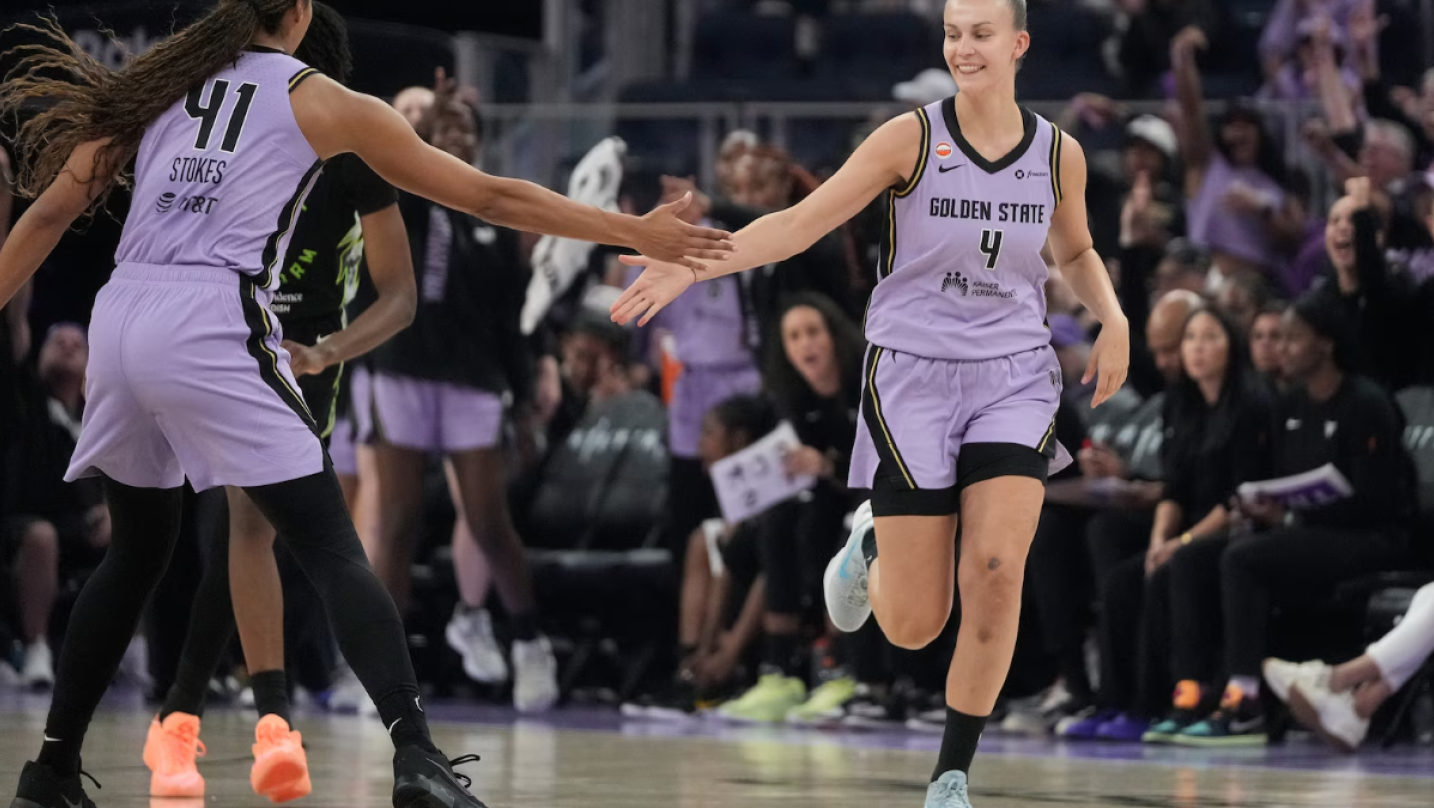 Golden State Valkyries embracing on the court at Chase Center