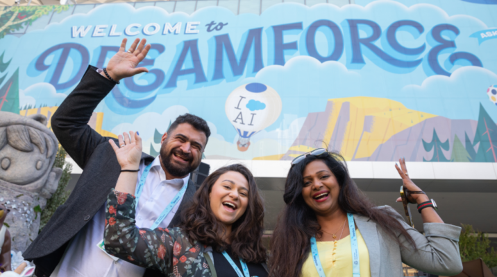 people pose in front of dreamforce postser