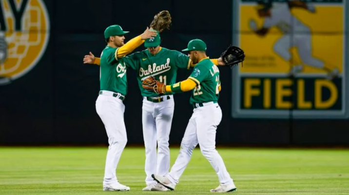 Athletics players embrace on the field