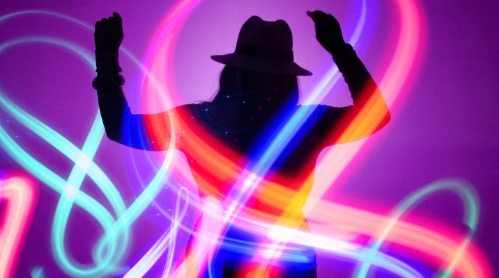 Person dancing in the lights at Glow at the Exploratorium. 